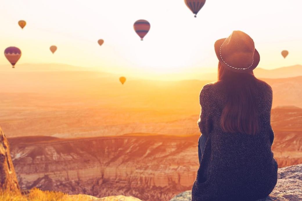 Eine Frau steht vor einem Horizont mit einigen Ballons