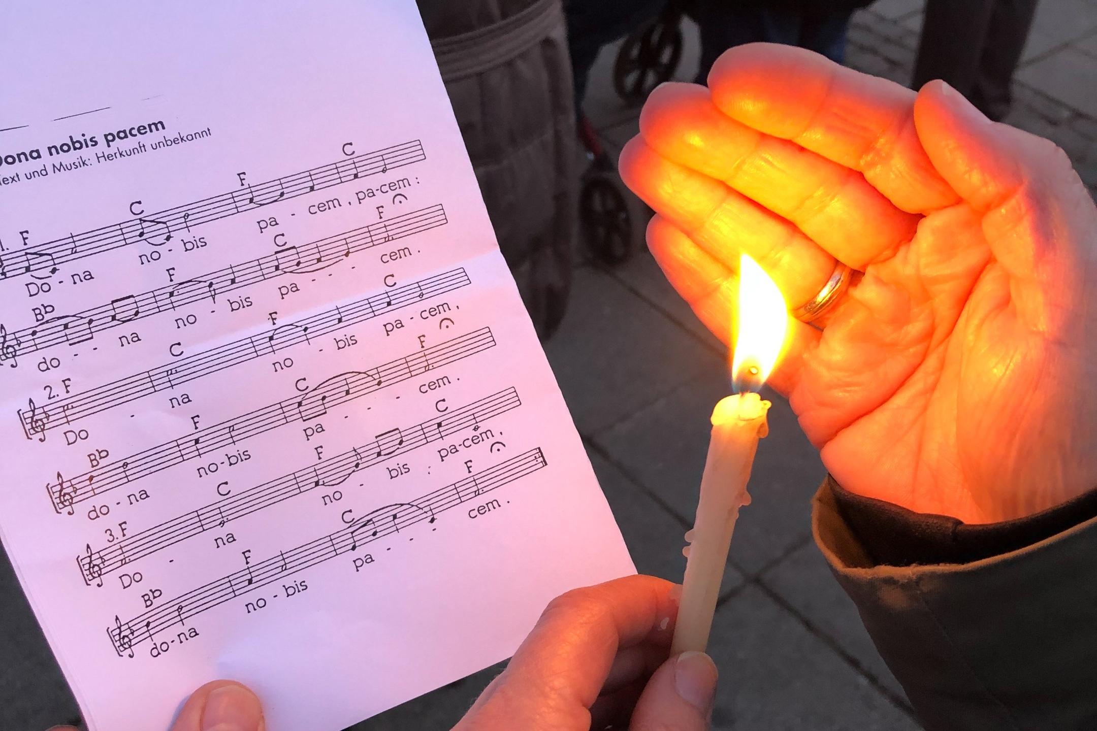 Eine Kerze scheint auf ein Liedblatt