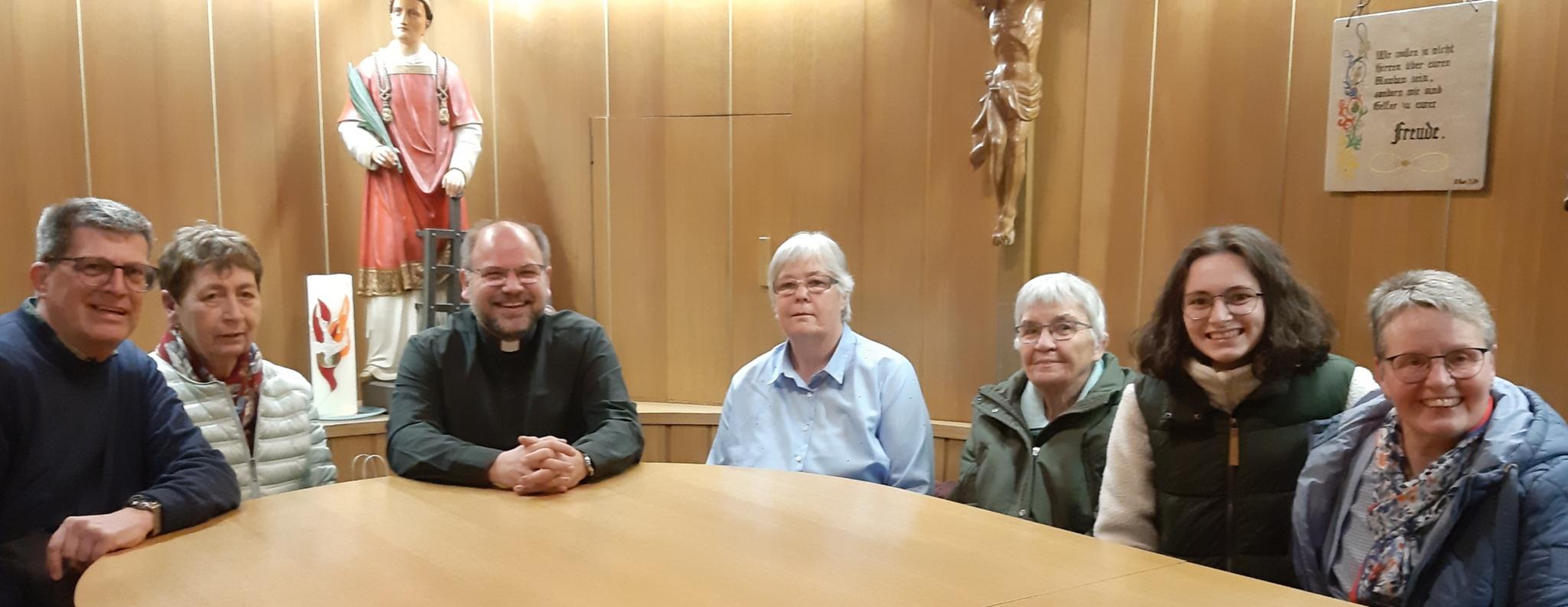 Eine Runde von Männer und Frauen sitzen an einem Tisch